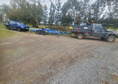 Pick up truck pulling trailer and a blue pick up truck